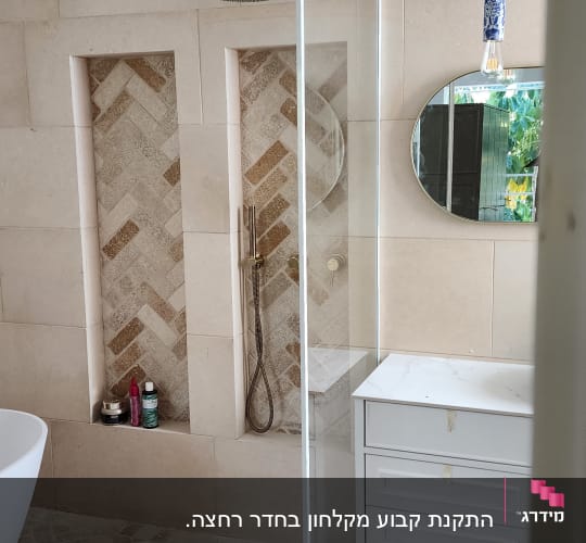 מקלחת עם ראש מקלחת זהב ומוצרים על מדף